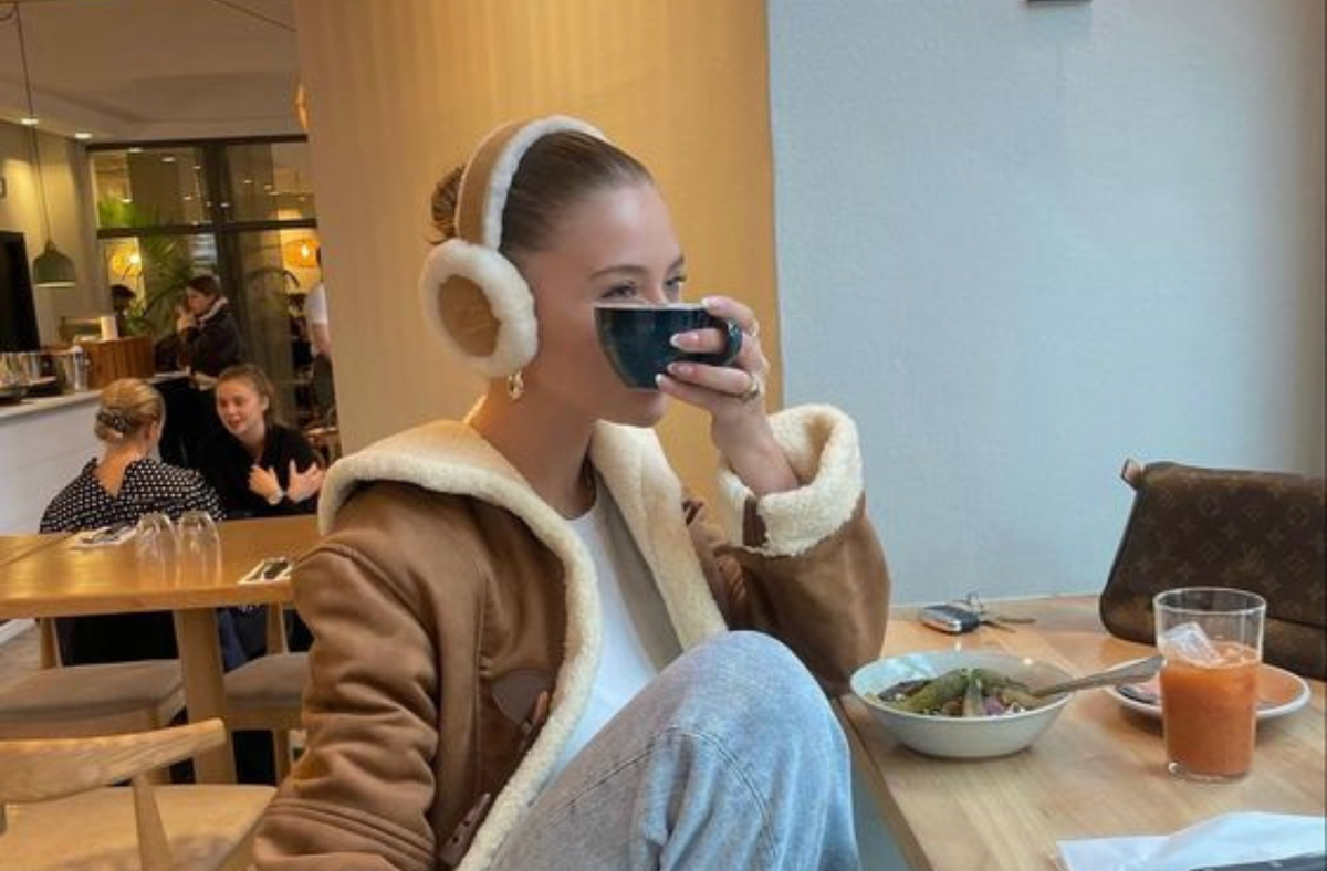 women at cafe wearing earmuffs drinking coffee in the winter