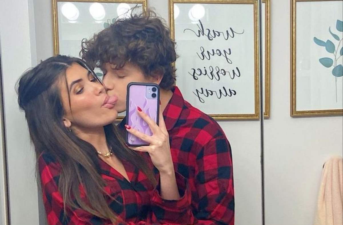 couple taking mirror selfie wearing red plaid pajama set