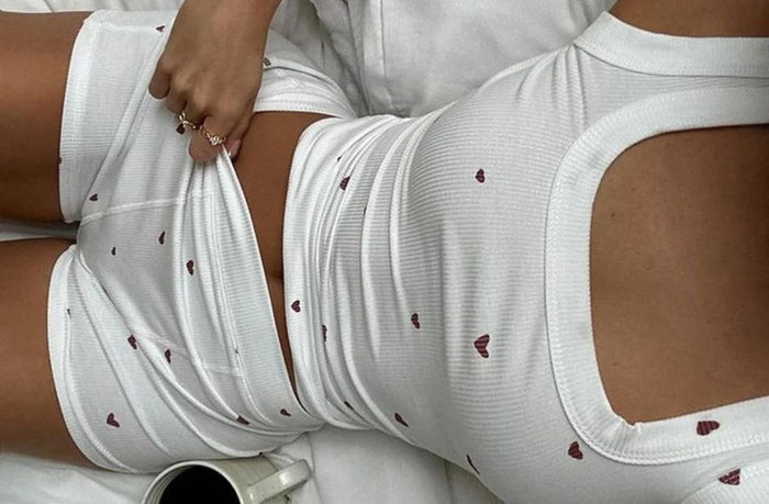 petite women wearing white pajama set with red hearts