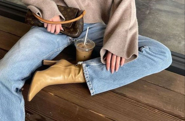 women sitting down wearing straight jeans light wash 