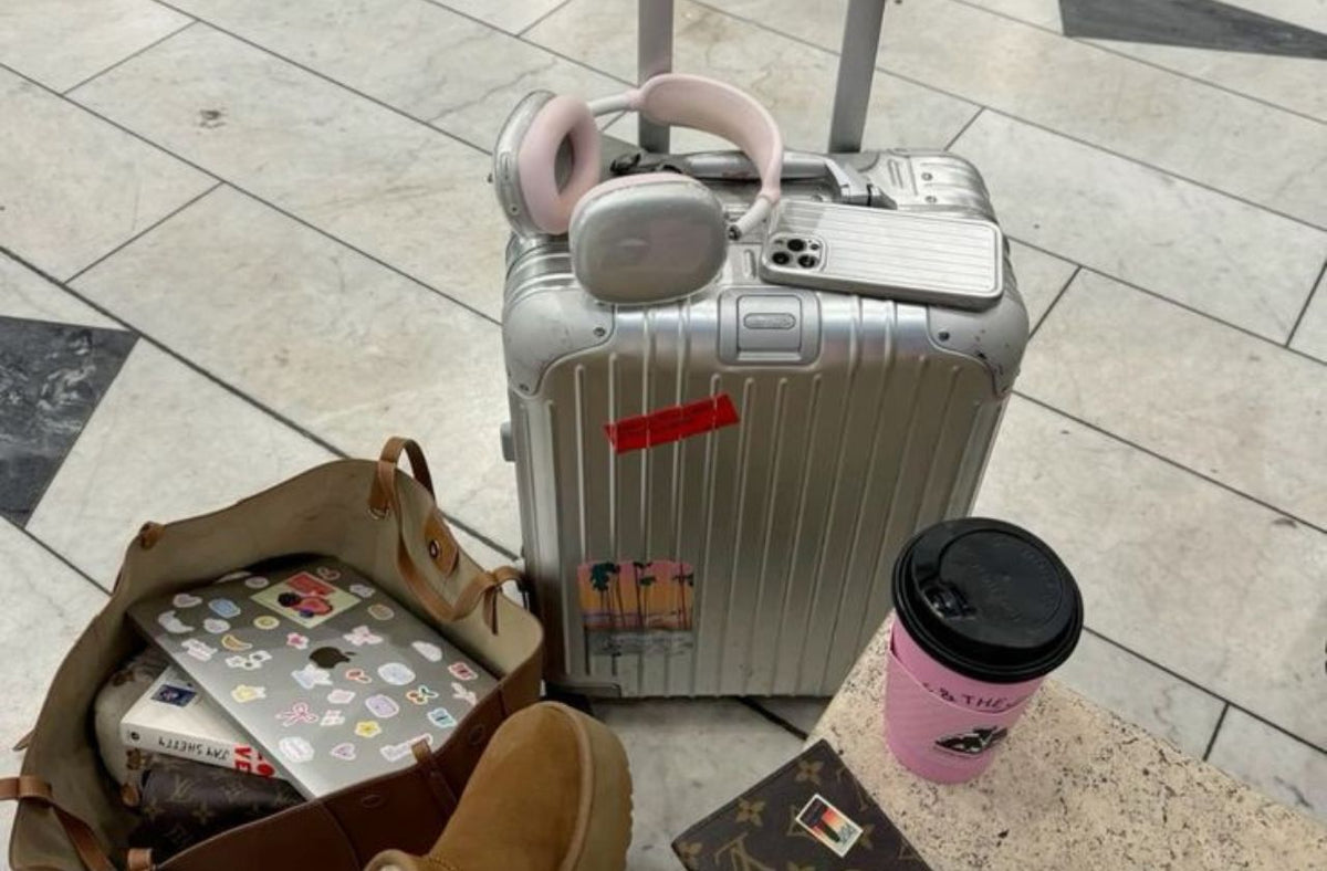 women at airport with suitcase and travel gadget